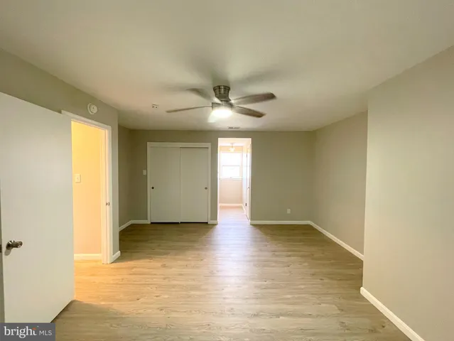 a view of an empty room with window and wooden floor