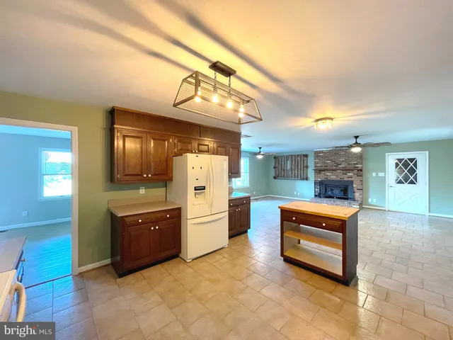a view of kitchen with stainless steel appliances cabinets and front door