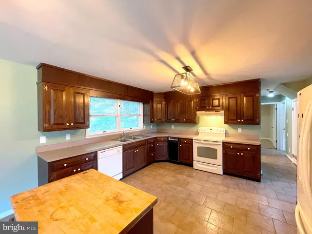 a large kitchen with stainless steel appliances granite countertop a sink and cabinets