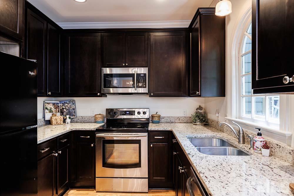 6814 Gloucester Road Raleigh, NC 27612 - Photo 13 of 35 a kitchen with stainless steel appliances granite countertop a sink stove and microwave