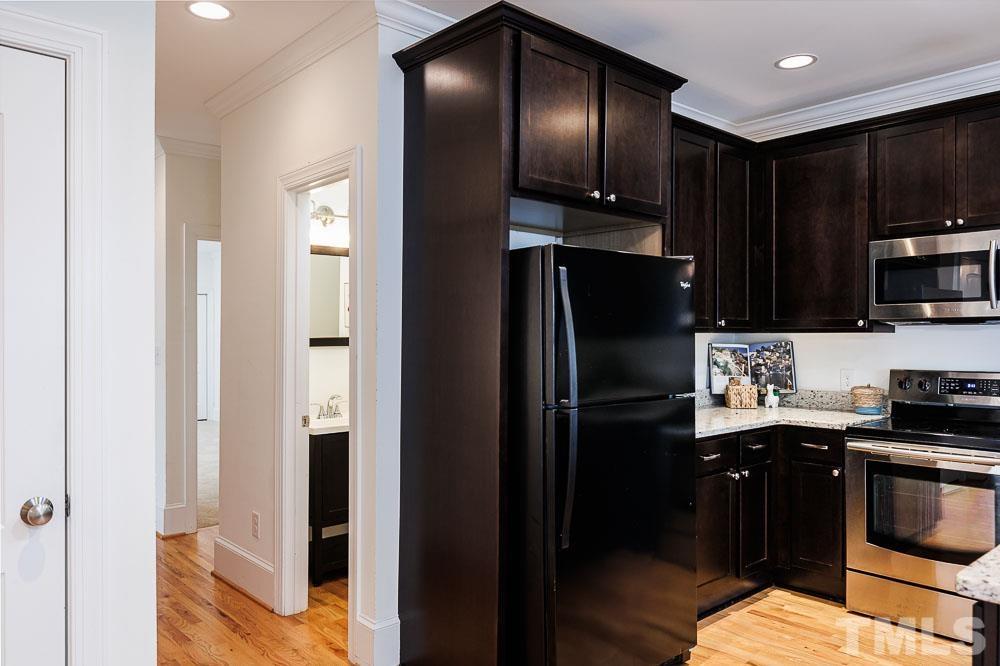 6814 Gloucester Road Raleigh, NC 27612 - Photo 14 of 35 a kitchen with stainless steel appliances granite countertop a refrigerator and a stove top oven