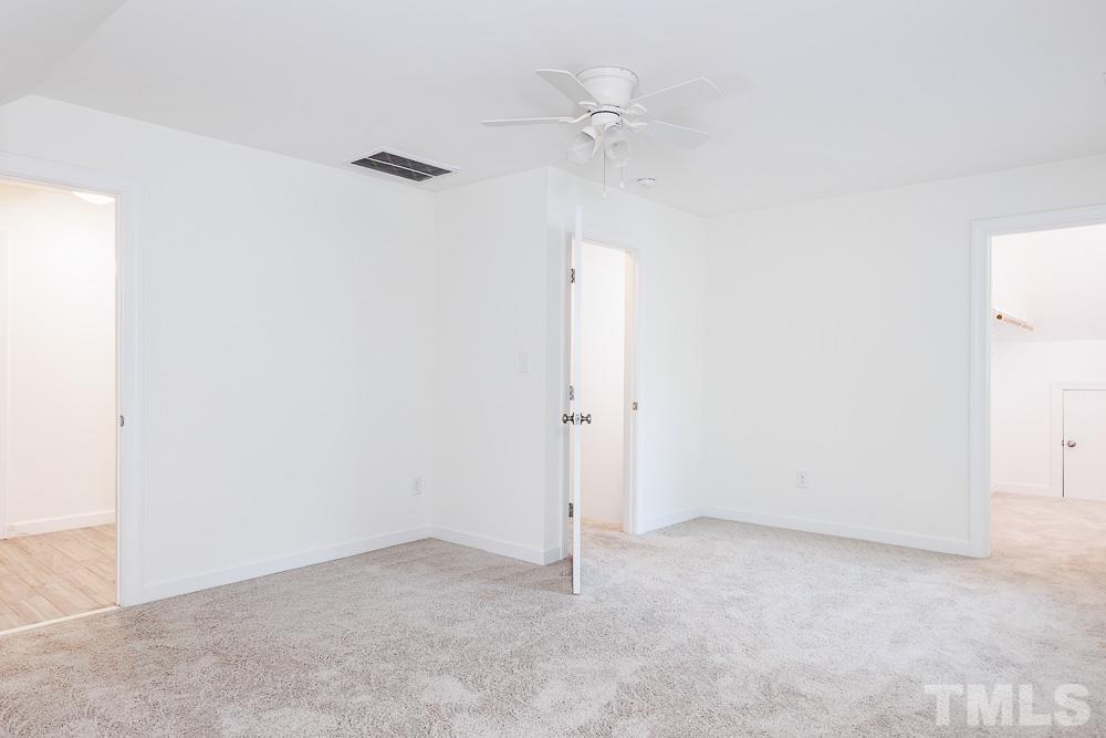 6814 Gloucester Road Raleigh, NC 27612 - Photo 23 of 35 an empty room with a ceiling fan and a window