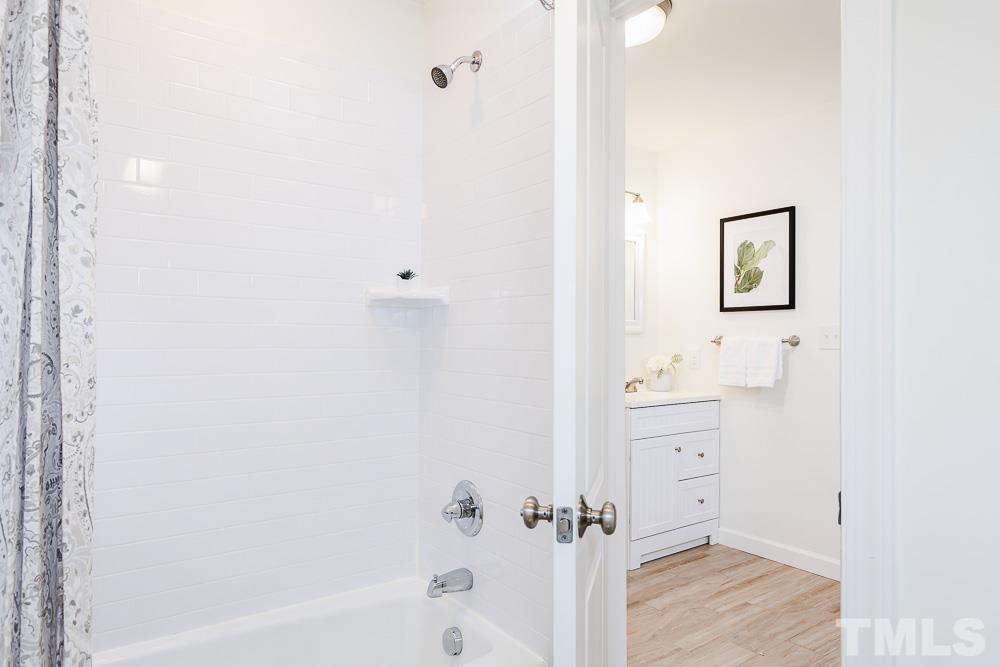 6814 Gloucester Road Raleigh, NC 27612 - Photo 25 of 35 a bathroom with a bathtub and a shower