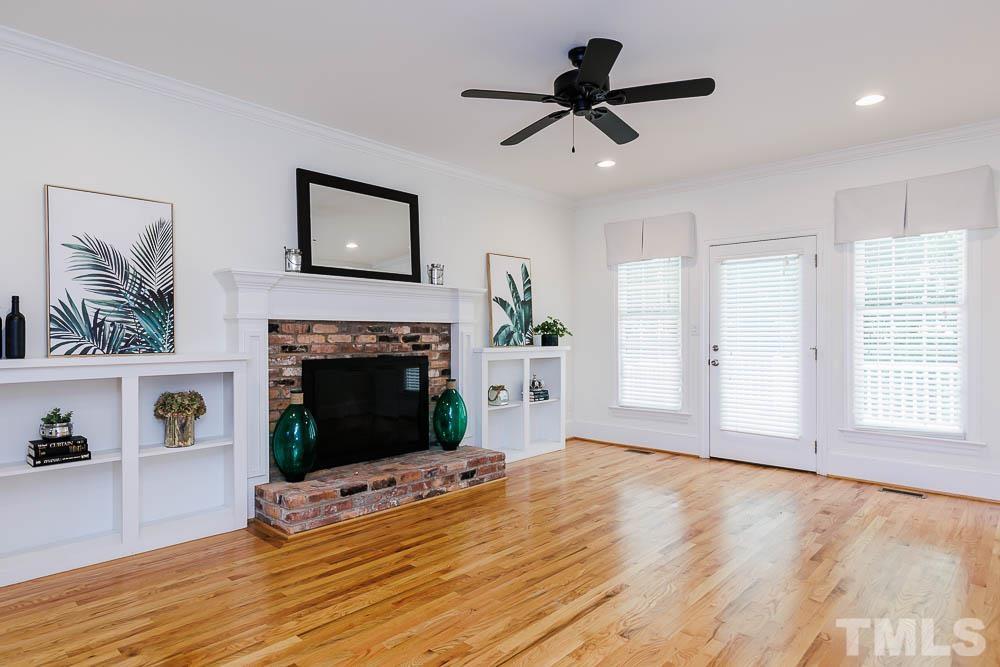 6814 Gloucester Road Raleigh, NC 27612 - Photo 8 of 35 a view of a livingroom with a fireplace a ceiling fan and a window