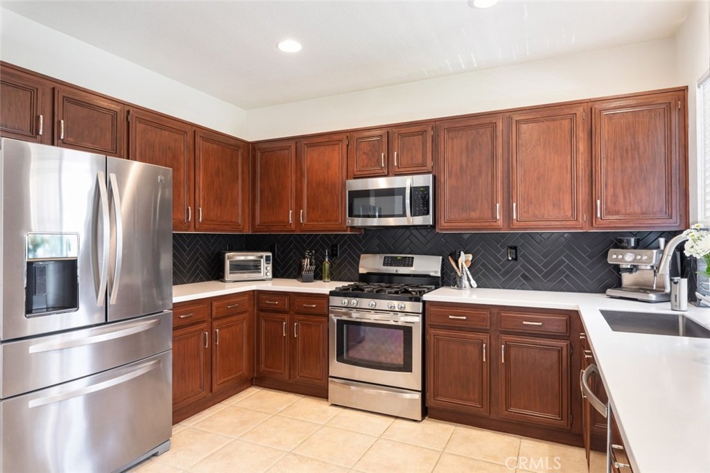 1430 Baldwin Drive Corona, CA 92881 - Photo 22 of 61 a kitchen with a sink stove and white stainless steel appliances