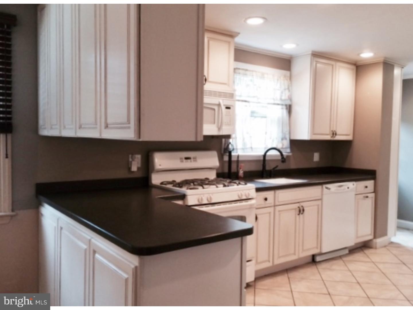 737 Hilltop Road Springfield, PA 19064 - Photo 11 of 24 a kitchen with granite countertop a sink white cabinets and black appliances