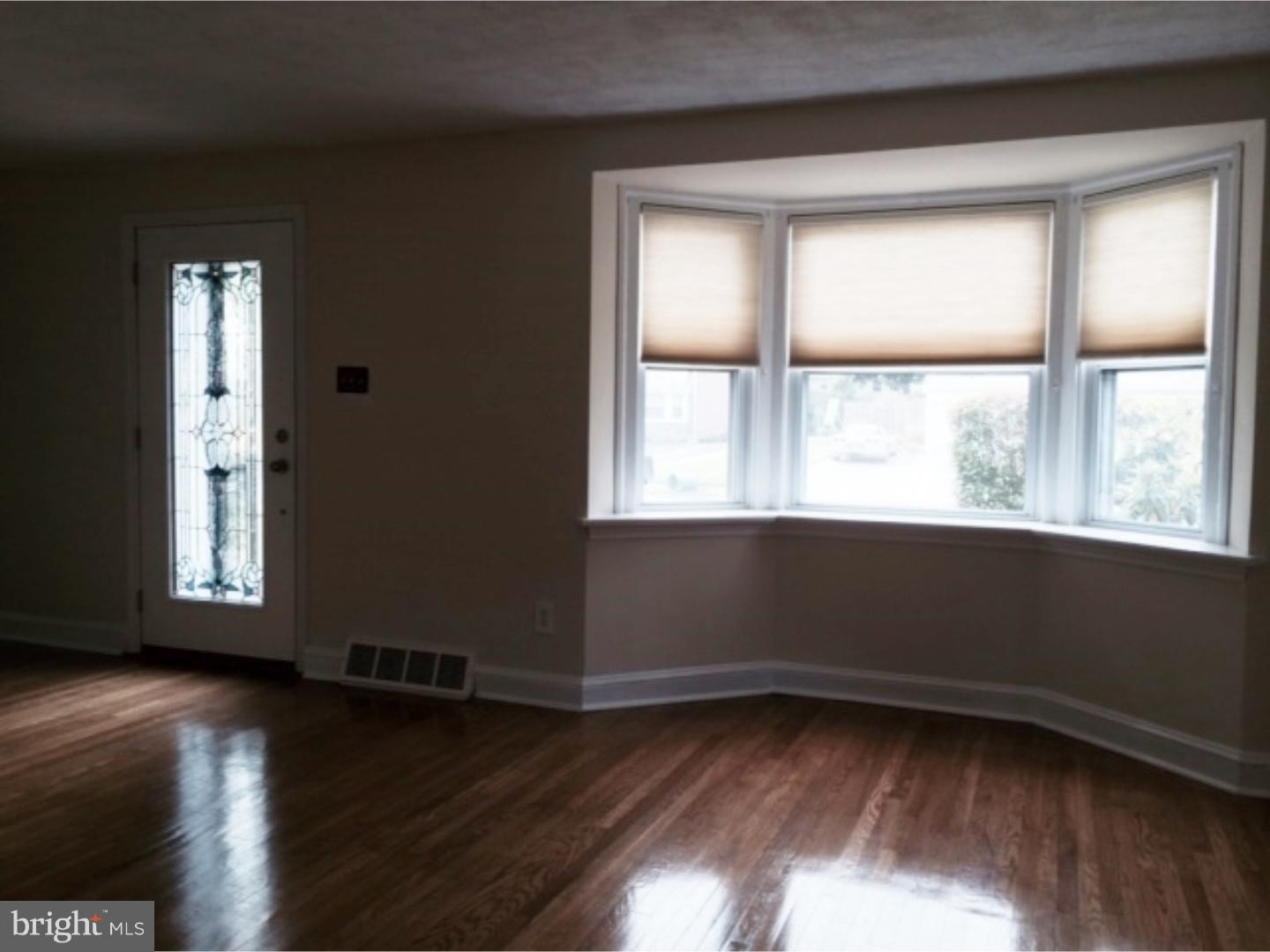 737 Hilltop Road Springfield, PA 19064 - Photo 3 of 24 a view of an empty room with wooden floor and a window