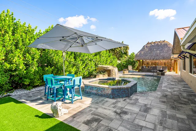 a patio with a table and chairs under an umbrella