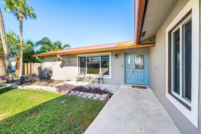 a front view of a house with a garden and patio