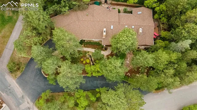 an aerial view of house with yard and trees in the background
