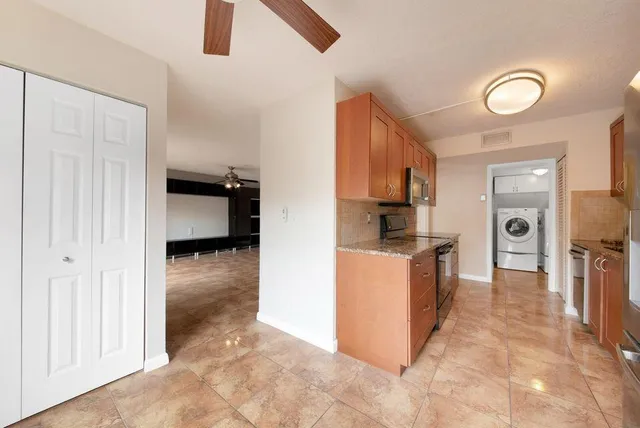 a kitchen with stainless steel appliances granite countertop a sink a stove and a refrigerator