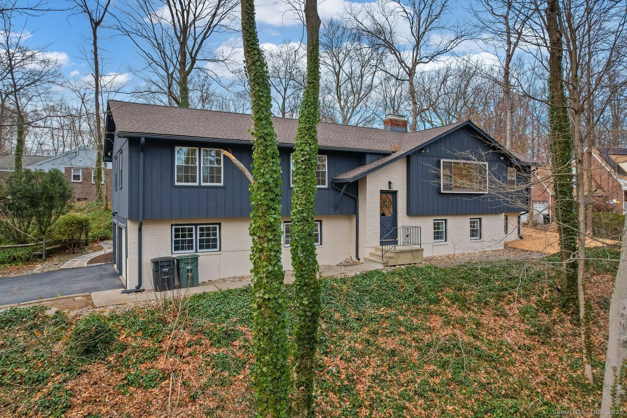 a front view of a house with plants and trees