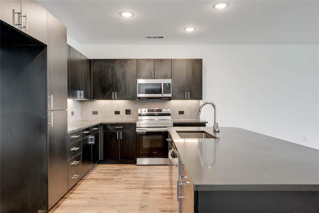 4801 Springdale Road, Unit 1307 Austin, TX 78723 - Photo 5 of 30 a kitchen with stainless steel appliances a stove sink microwave and cabinets
