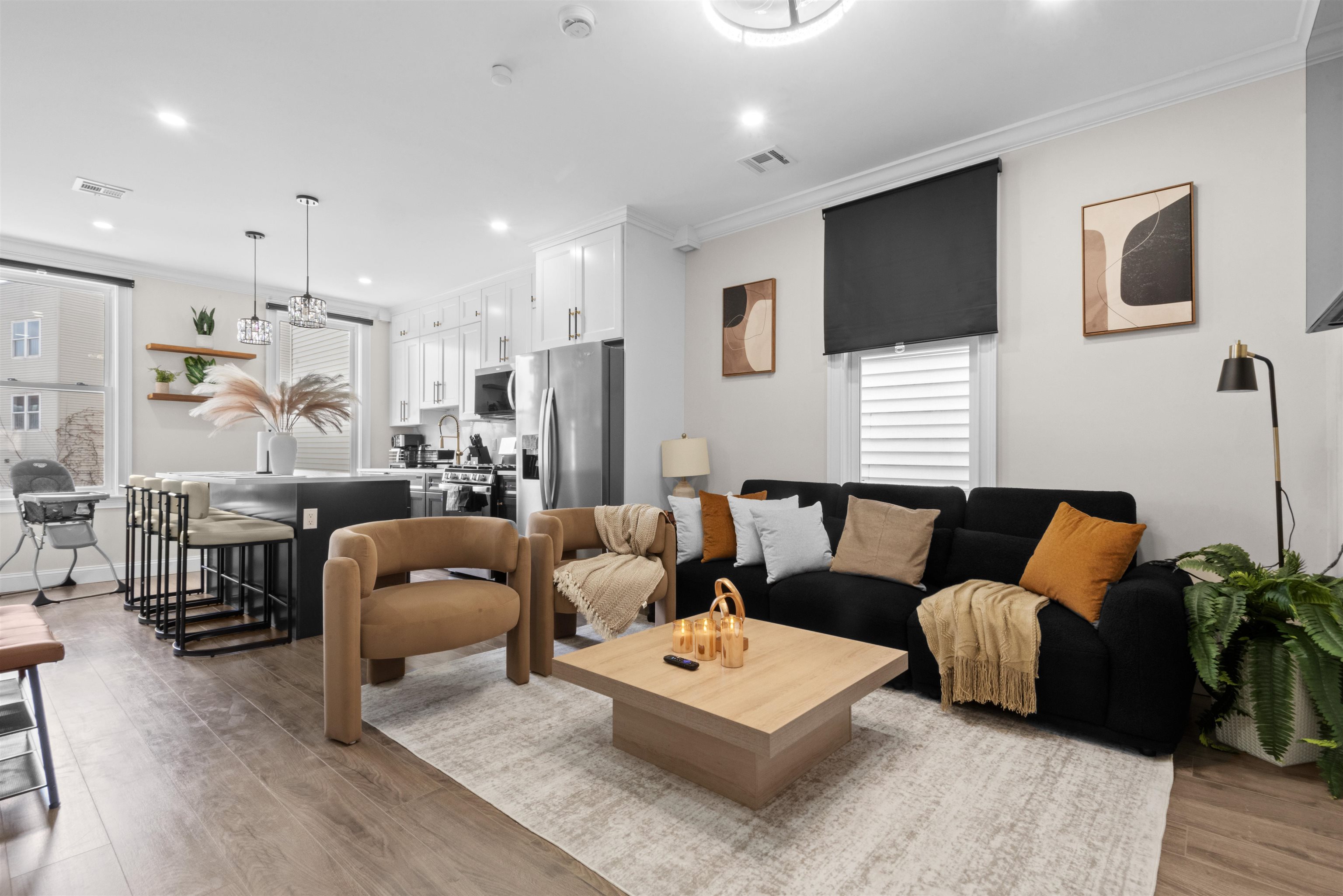 a living room with furniture a flat screen tv and kitchen view