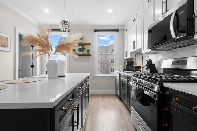 a kitchen with stainless steel appliances granite countertop a sink a stove oven a counter space and cabinets