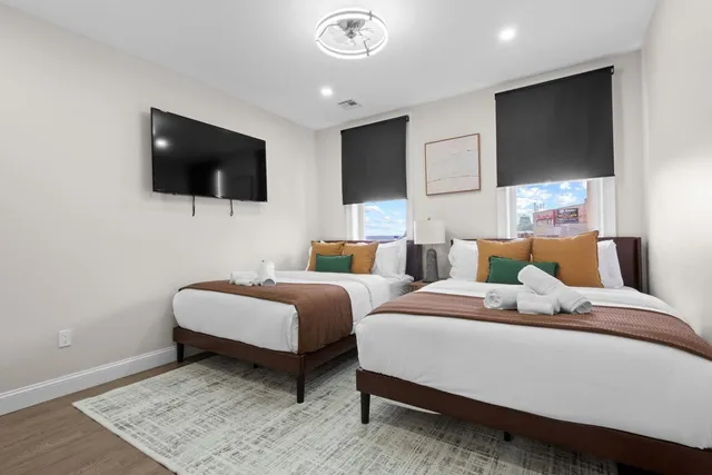 a bedroom with two beds and a flat screen tv