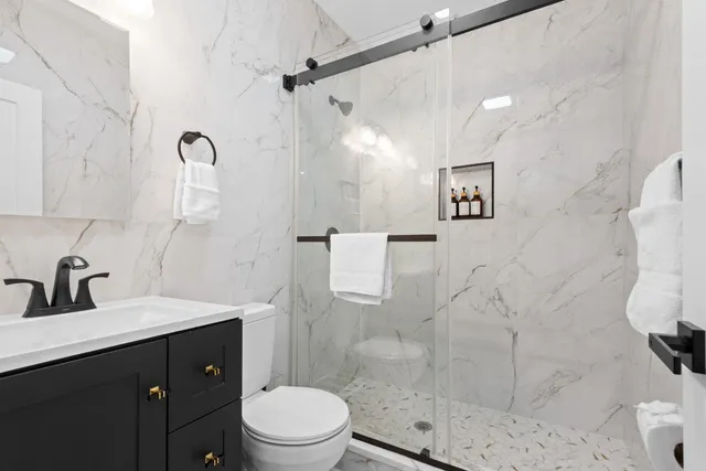 a bathroom with a sink a toilet and shower