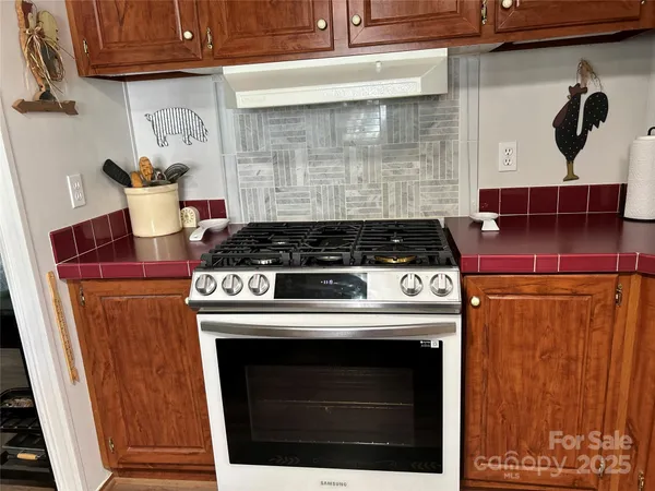 a stove top oven sitting inside of a kitchen