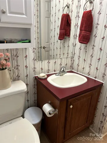 a bathroom with a sink a toilet and a mirror