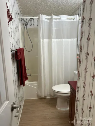 a bathroom with a shower a toilet and sink
