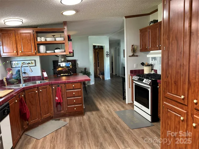 a kitchen with stainless steel appliances kitchen island granite countertop a stove a sink and a refrigerator