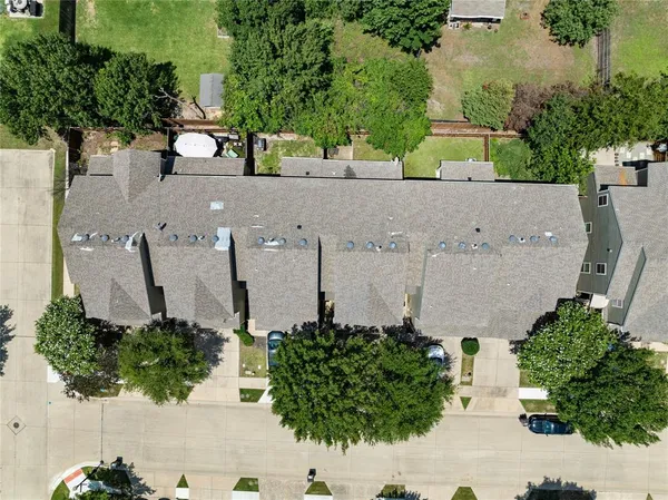 an aerial view of a house with a yard and large trees