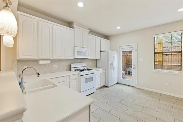 a kitchen with white cabinets and white appliances