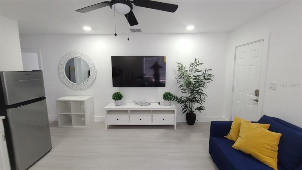 2519 West Walnut Street Tampa, FL 33607 - Photo 6 of 19 a living room with furniture a mirror and a flat screen tv