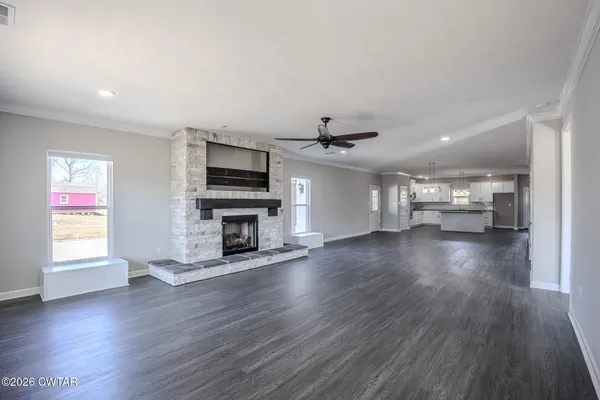 a view of a livingroom with furniture a flat screen tv and fireplace