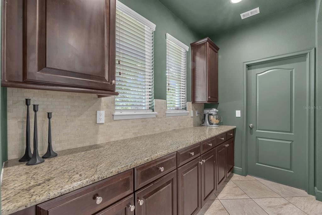 5310 Fishhawk Ridge Drive Lithia, FL 33547 - Photo 18 of 52 a kitchen with stainless steel appliances granite countertop a sink and a wooden cabinets