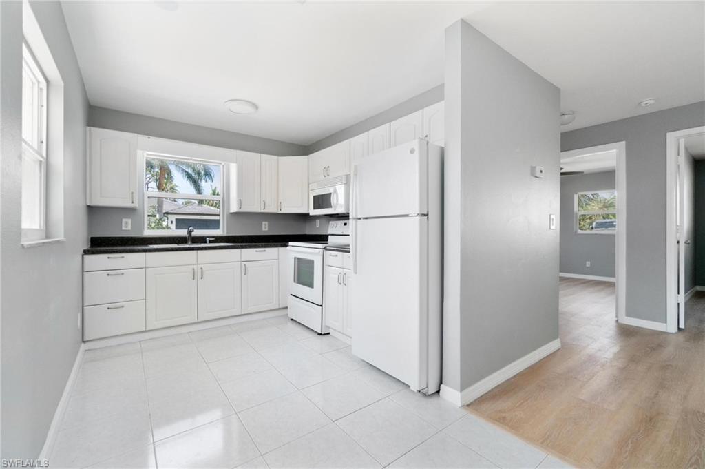 4337-4339 Mariner Road Bonita Springs, FL 34134 - Photo 12 of 29 a kitchen with white cabinets and white appliances