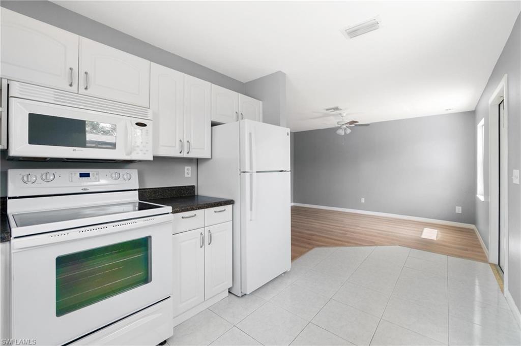 4337-4339 Mariner Road Bonita Springs, FL 34134 - Photo 14 of 29 a kitchen with white cabinets and white appliances