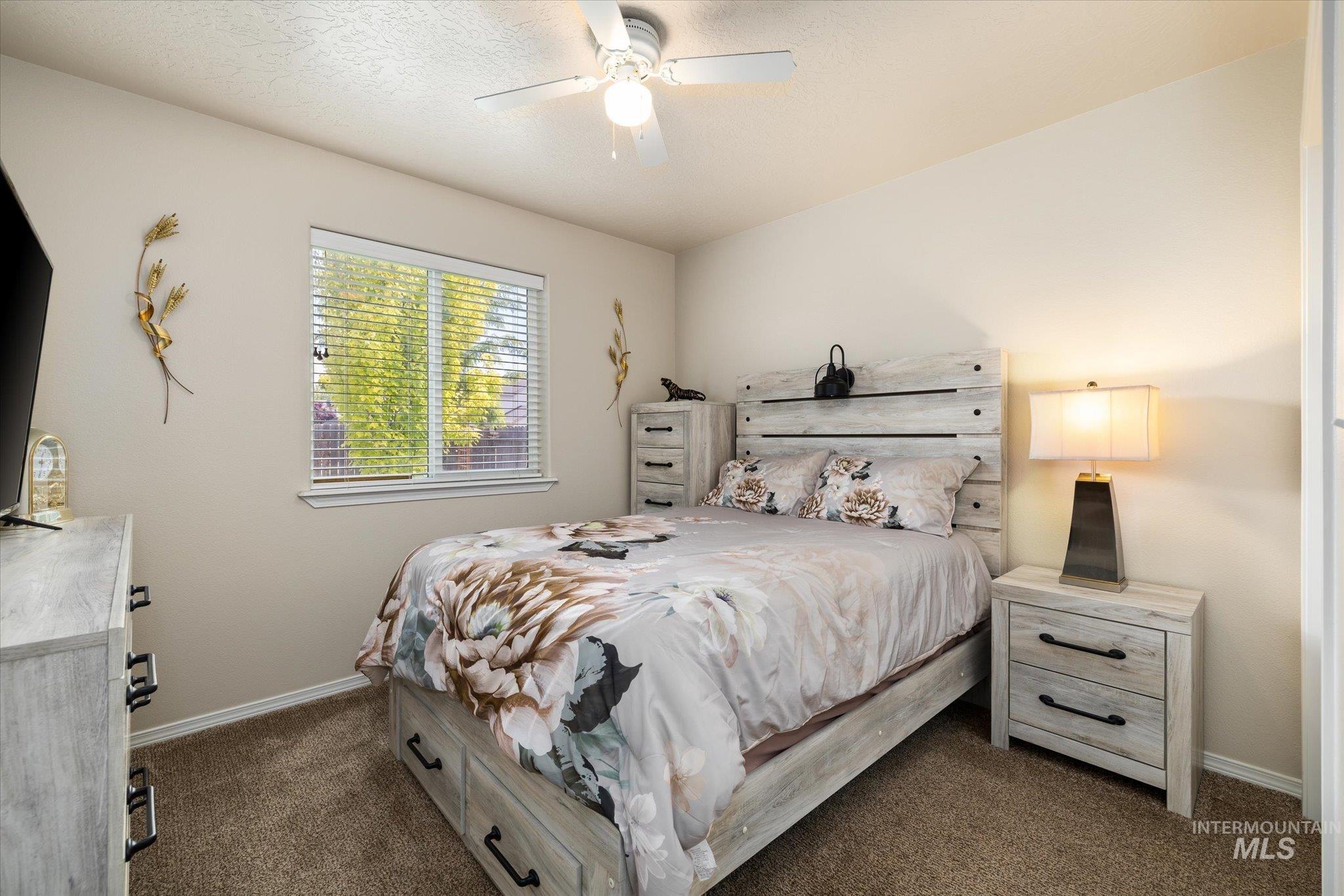 5401 Barkley Way Caldwell, ID 83607 - Photo 8 of 35 Neutral-toned bedroom featuring a window with blinds, a ceiling fan with light fixture, light beige walls, and plush carpet flooring