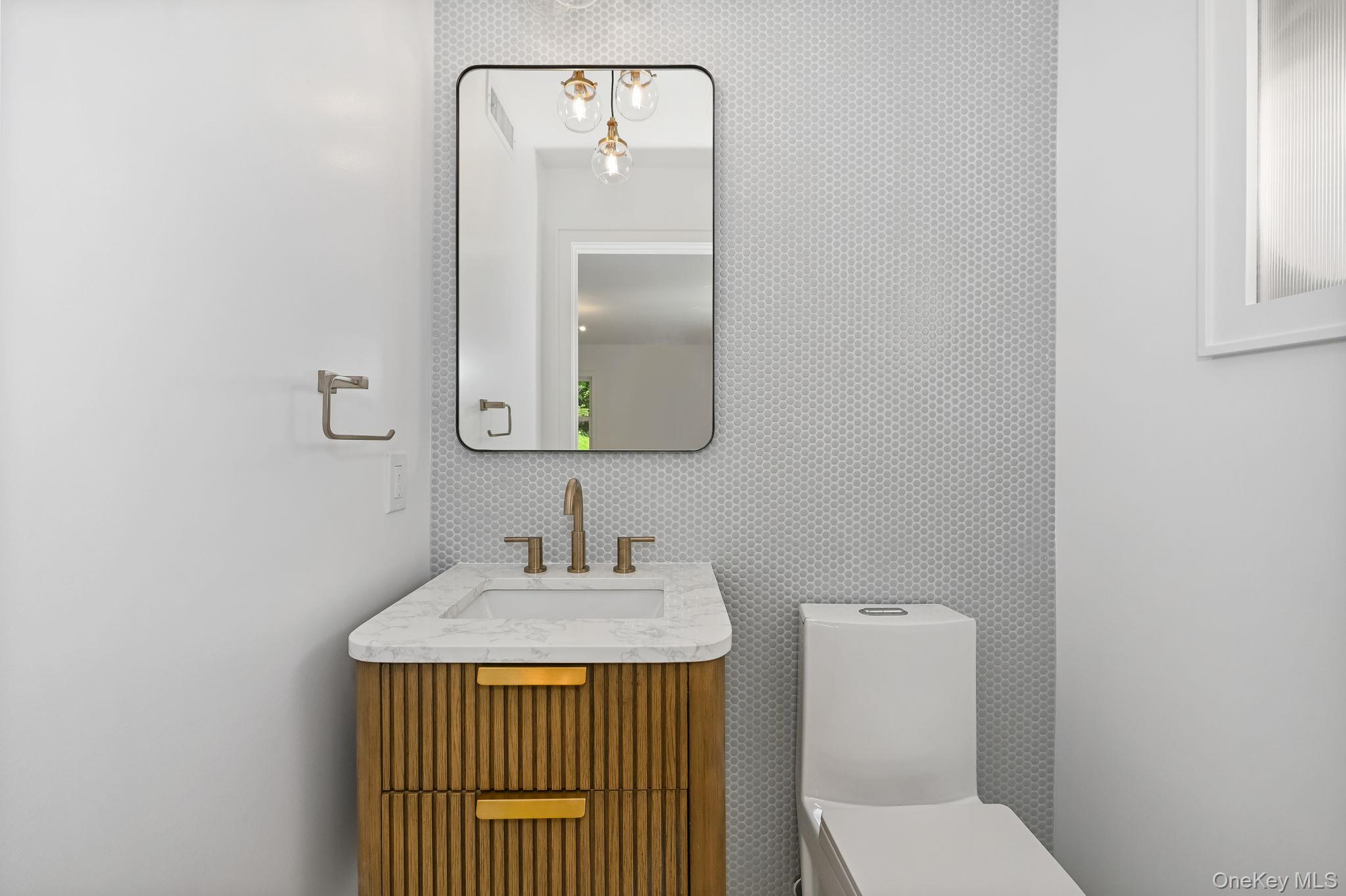 24 Country Road Mamaroneck, NY 10543 - Photo 13 of 37 a bathroom with a sink a toilet and mirror