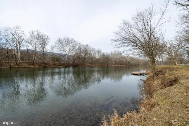 a view of wooden deck next to a lake with trees