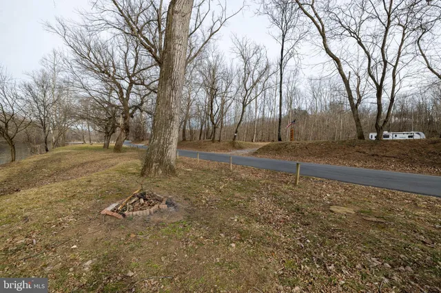 a view of a lake with chairs and wooden fence