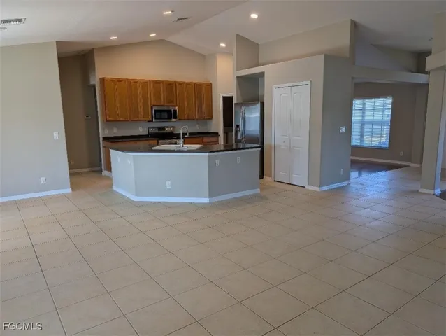 a large kitchen with stainless steel appliances a refrigerator and a stove top oven
