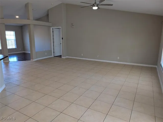 an empty room with fan and a window