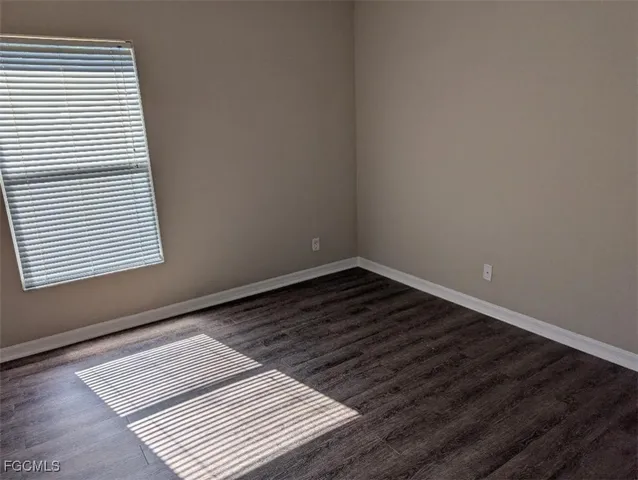 a view of a room with wooden floor and a window