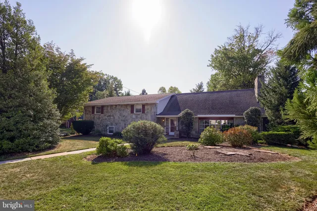 a view of a house with a yard and a large tree