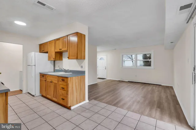 a view of empty room with wooden floor and fireplace