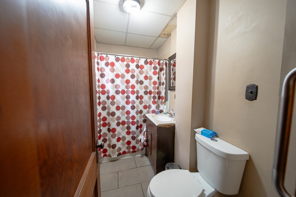 42 Morton Street Lawrence, MA 01841 - Photo 12 of 24 a white toilet sitting next to a shower curtain