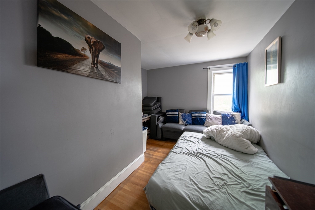 42 Morton Street Lawrence, MA 01841 - Photo 20 of 24 a bedroom with a bed and a chandelier