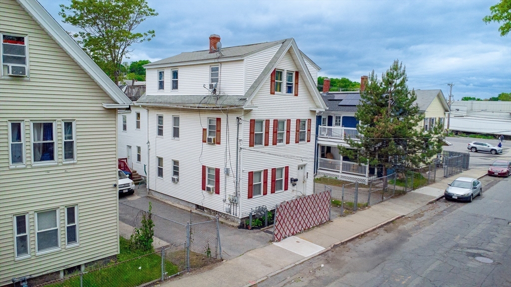 42 Morton Street Lawrence, MA 01841 - Photo 3 of 24 a view of a white house with a small yard and potted plants