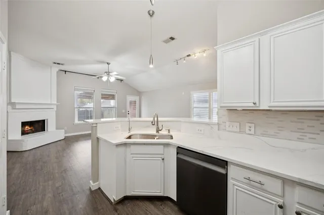 a kitchen with a sink dishwasher a stove and a refrigerator with wooden floor