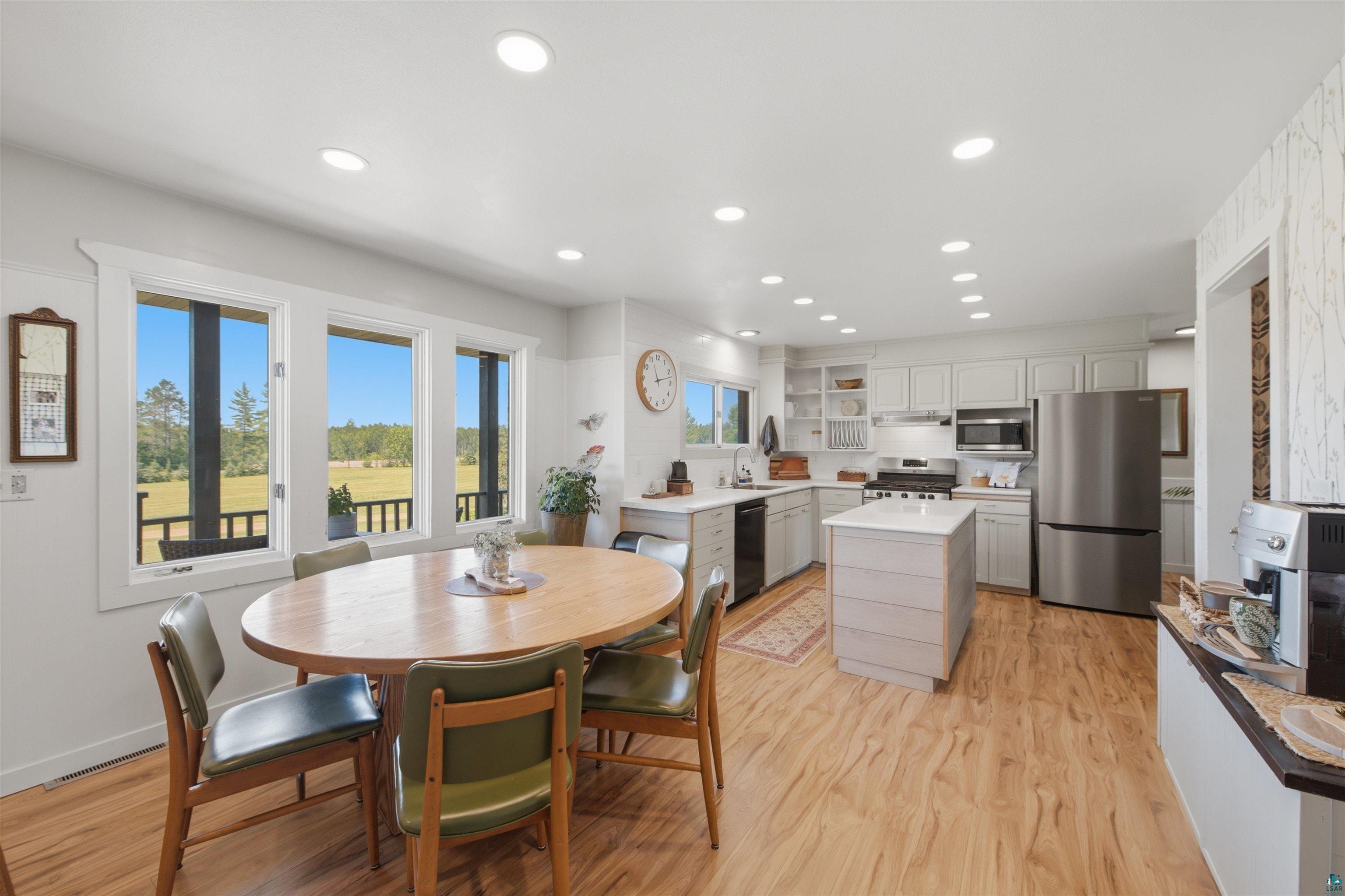 64260 Jolma Road Ashland, WI 54806 - Photo 7 of 35 Open-concept kitchen and dining area featuring wood-finish flooring, recessed lighting, and a kitchen island with a light-toned countertop