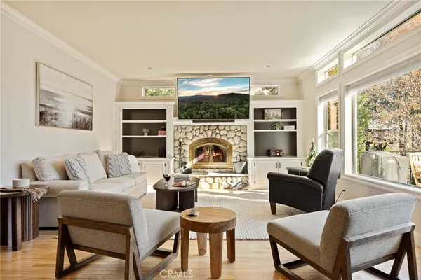 a living room with furniture a large window and a fireplace
