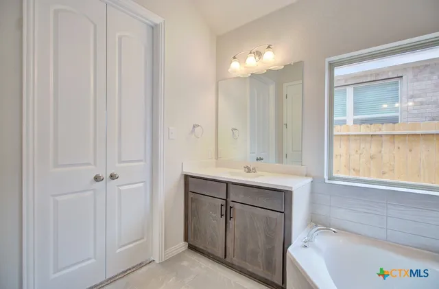 a bathroom with a tub sink and mirror