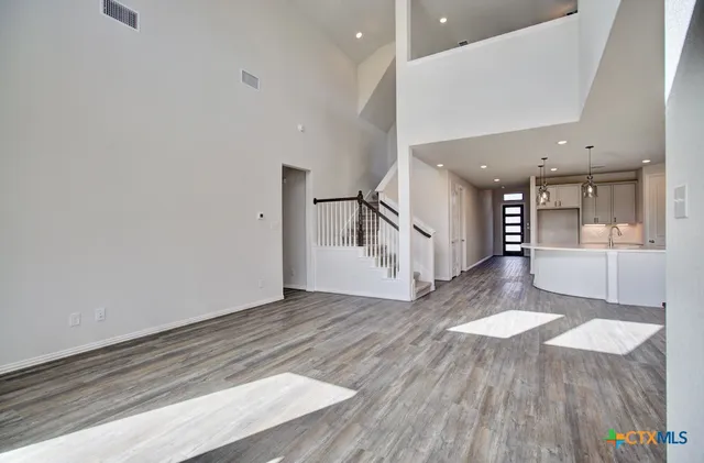 a view of a hallway with wooden floor and stairs