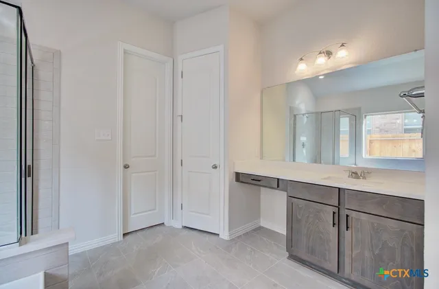 a spacious bathroom with a double vanity sink and a mirror